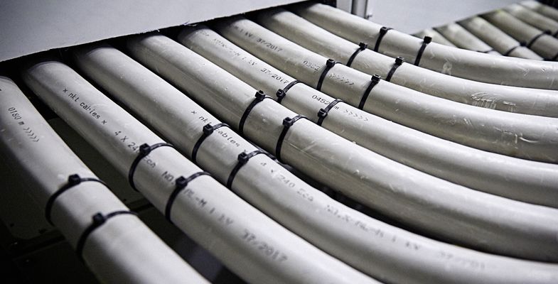 Seven white 1 kV cables laying side by side